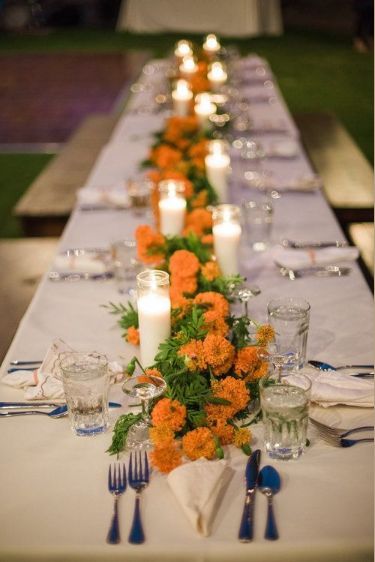 This may contain: a long table with candles and flowers on it